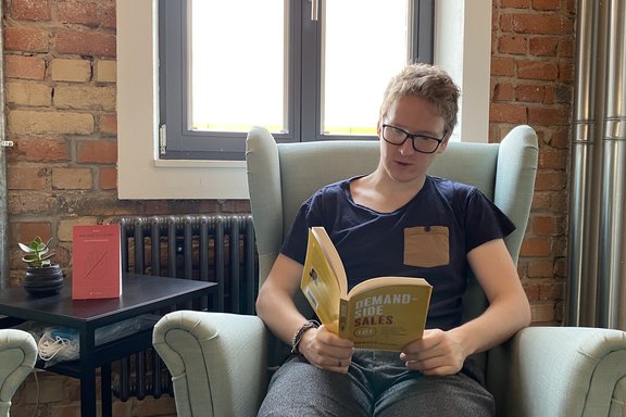Max sitzt im Sessel und liest ein Buch